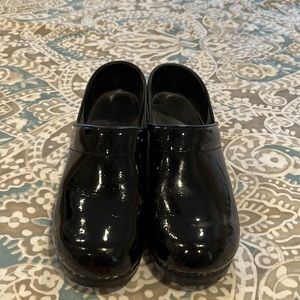 Sanita black patent clogs.